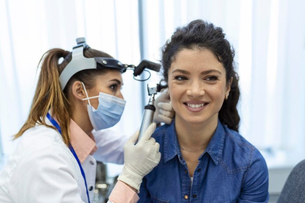 Audiologist examining a woman's ear
