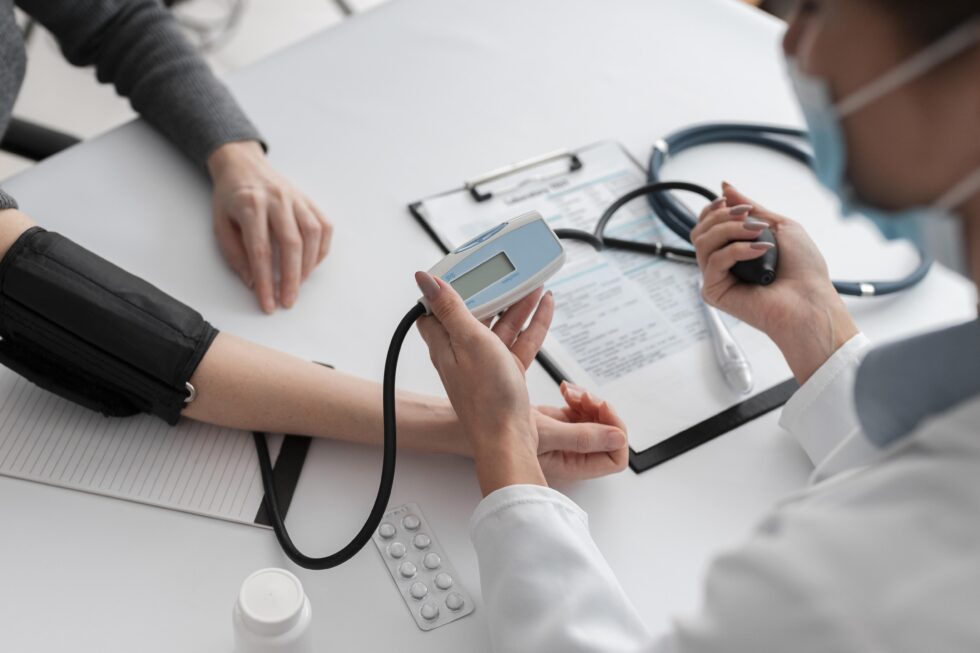 A healthcare professional conducts a routine health screening, checking a patient’s blood pressure while reviewing medical records and using standard diagnostic equipment.