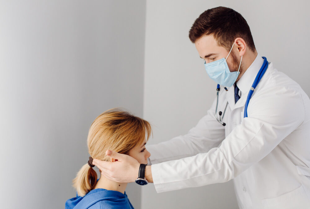 a doctor gently examining a young patient’s ear in a clean clinical setting.