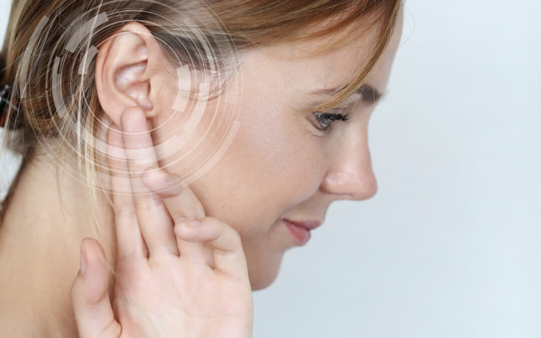 a woman touching her ear, representing ear discomfort, hearing difficulty, or an ear-related balance problem.
