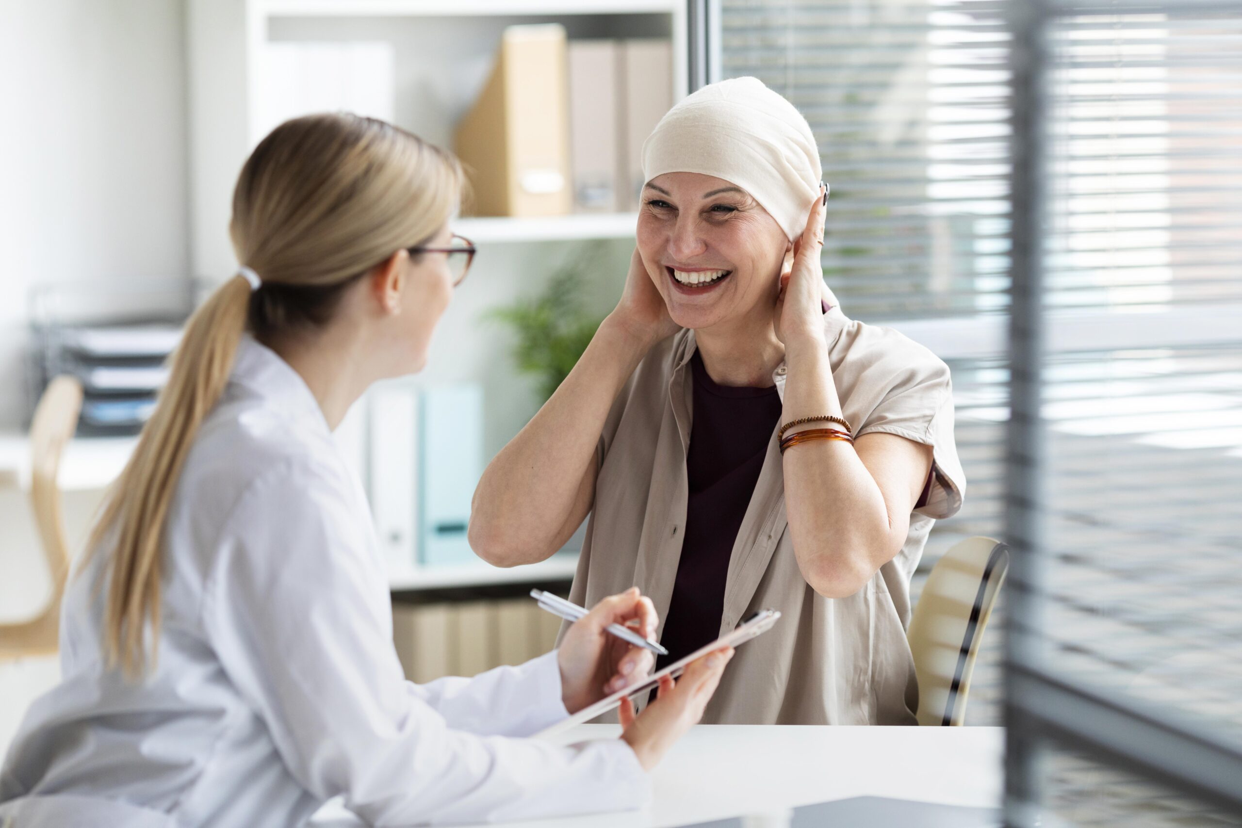 medical consultation between a female doctor and an adult female patient undergoing cancer-related care.