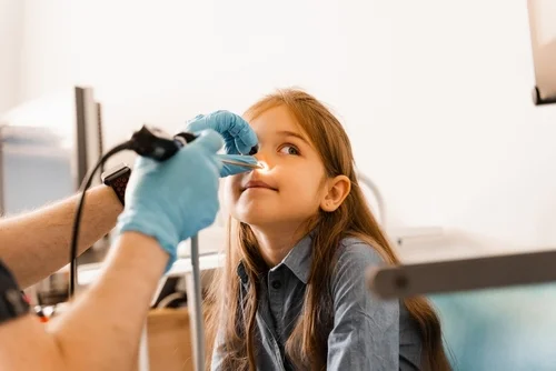 Doctor checking girls nose